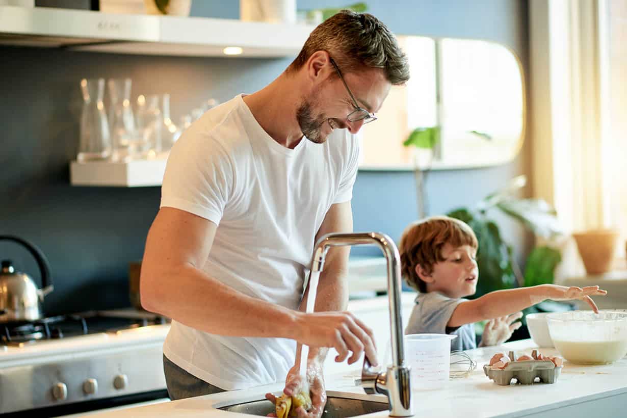 The boys are bonding father and son cooking at the counter
